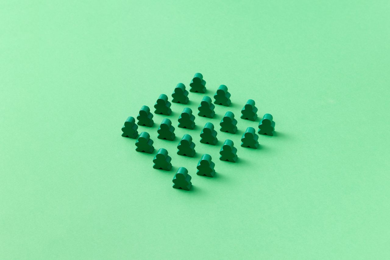 our-values Green meeples arranged neatly on a green background, showcasing minimalist design and pattern.